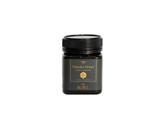Jar of Manuka Honey with a black lid on a white background